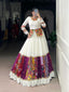 Model showcasing a premium milky white Chaniya Choli featuring full sleeves, a traditional embroidered peplum waist jacket bodice, and a heavy multi-pattern Patola and Gamthi patchwork panel border inside a boutique showroom.