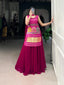 Model showcasing a premium pink Bandhani print sleeveless tunic kurti with multi-color traditional arch patchwork embroidery, heavy gold fringe hem, and solid flared pink georgette sharara pants inside a boutique.